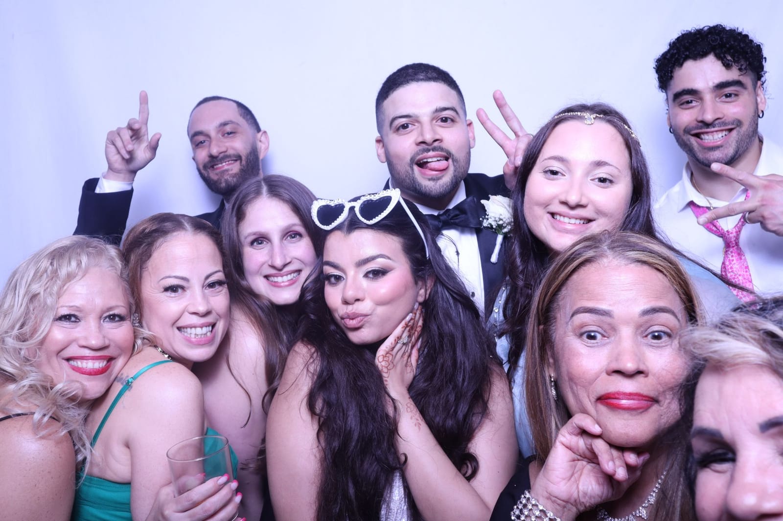 Wedding party crowding into the photo booth with the bride and groom at a Brooklyn reception